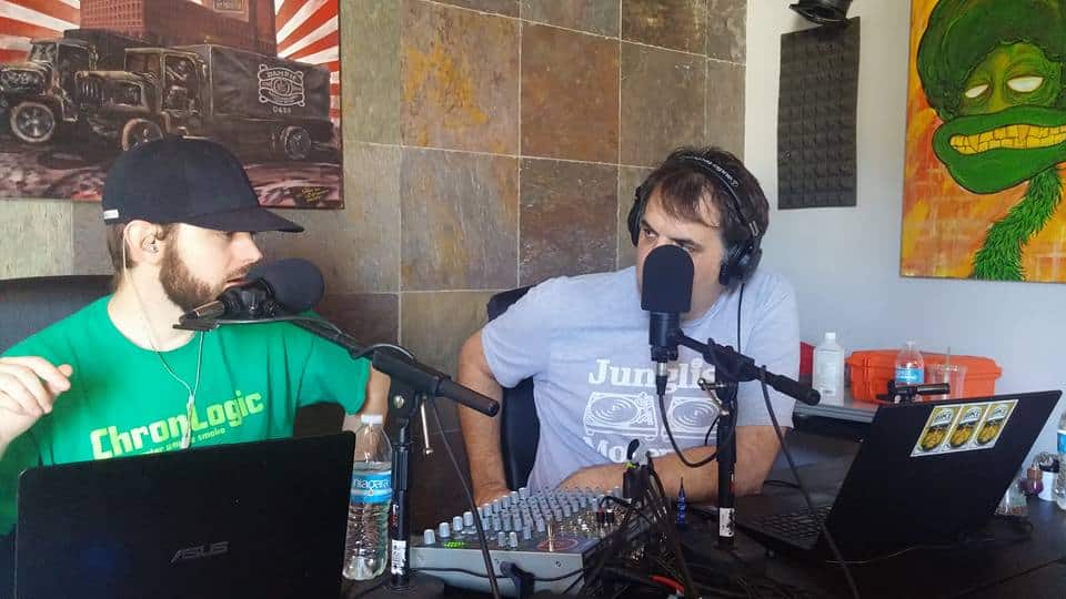 Tim Martin and his co-host, Bike Hawley, recorded the John Doe Radio Show in 2015. They sat at a table with microphones, laptops, and sound equipment. The two were engaged in a lively discussion.